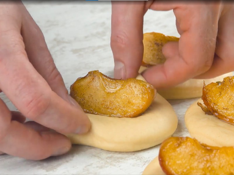 Apfelbrot aus der Pfanne: gebratene Äpfel auf runden Teigstücken, die gefaltet werden.