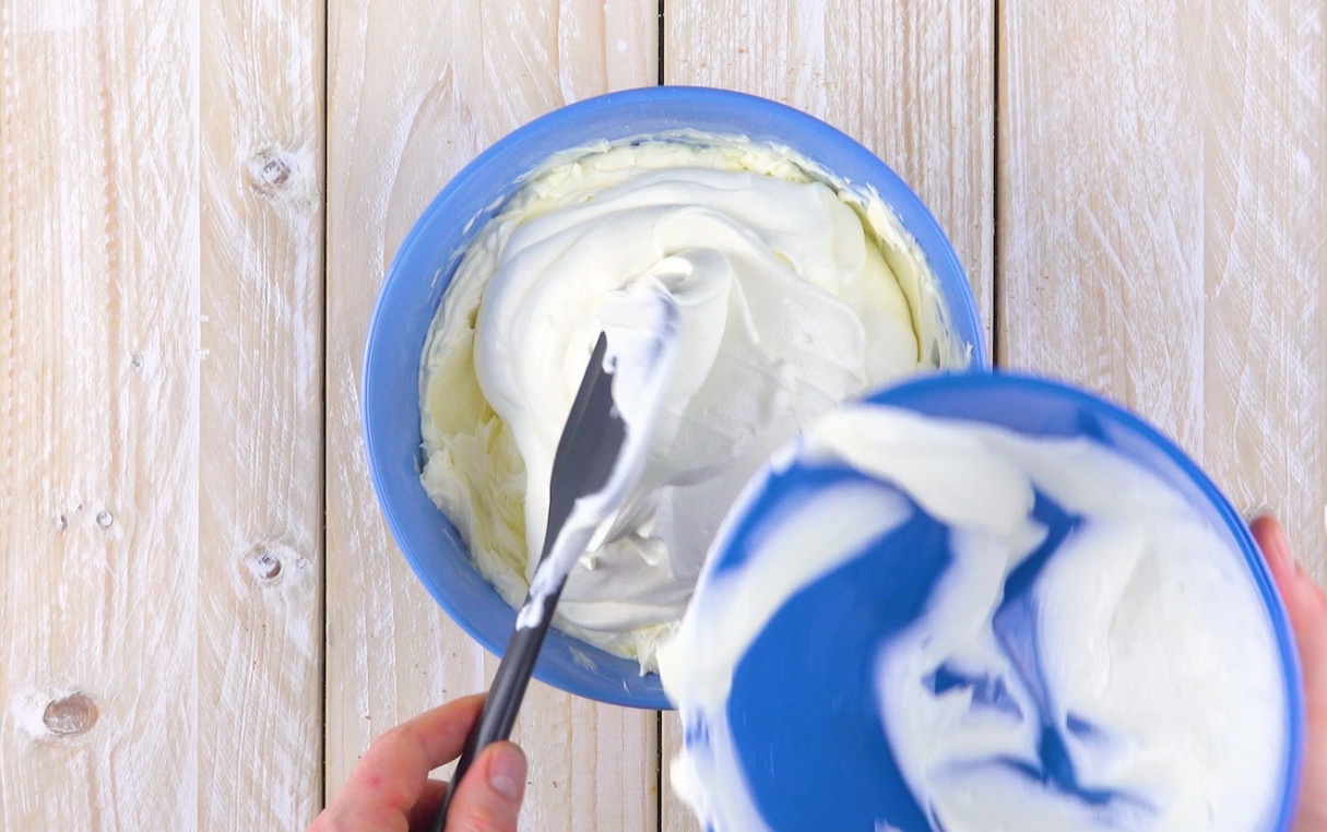 Schlagsahne wird zu Frischkäsecreme in Schüssel gegeben