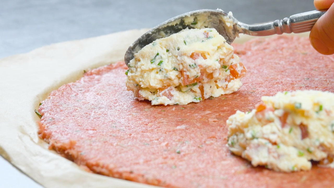 Käsefüllung wird in regelmäßigen Abständen auf Hackfleisch verteilt