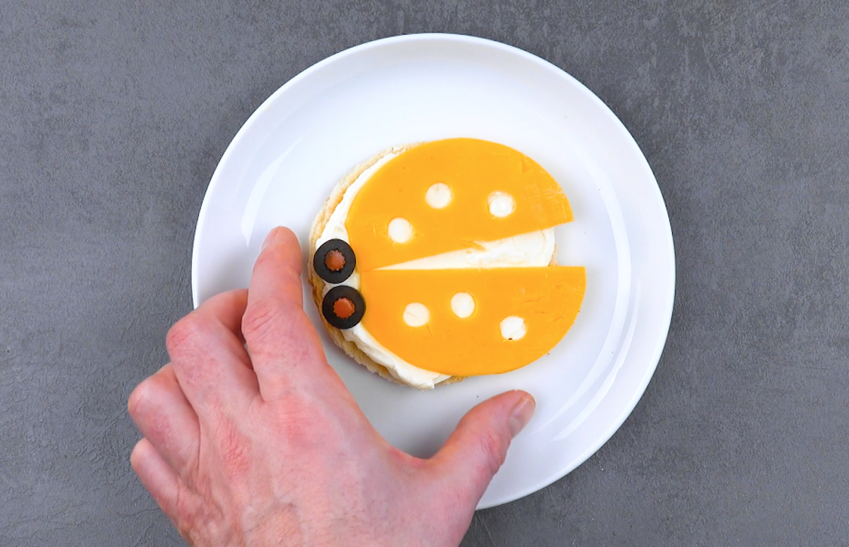 Ein gelber Marinekäfer aus Toast, Frischkäse und einer Scheibe Cheddar