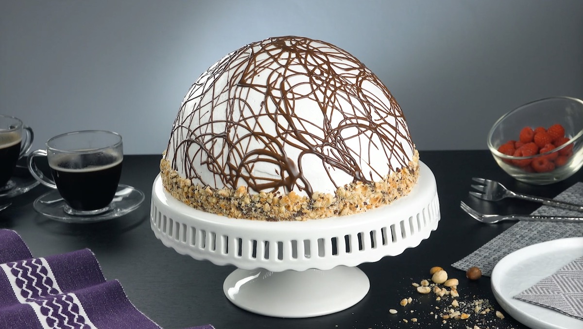 Kuppeltorte mit Ananas, Himbeeren, verziert mit gehackten Nüssen und Schokoganache