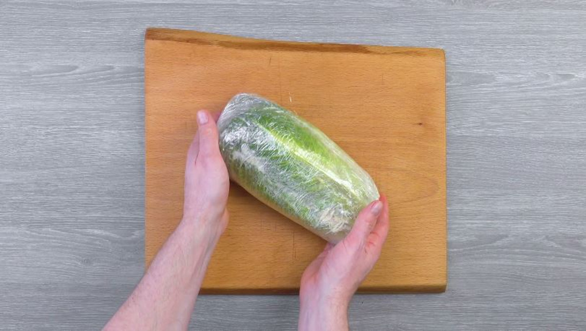 Der gefüllte Salat wird in Frischhaltefolie eingewickelt
