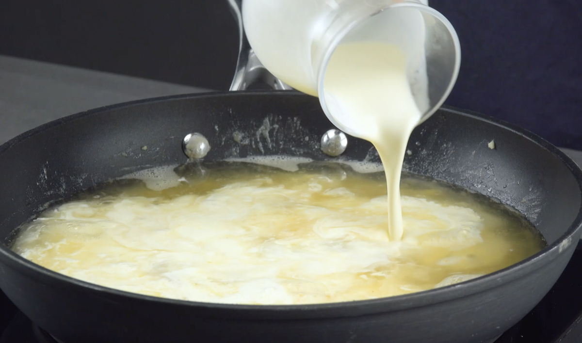 Hühnerbrühe und Sahne werden in Pfanne gegossen