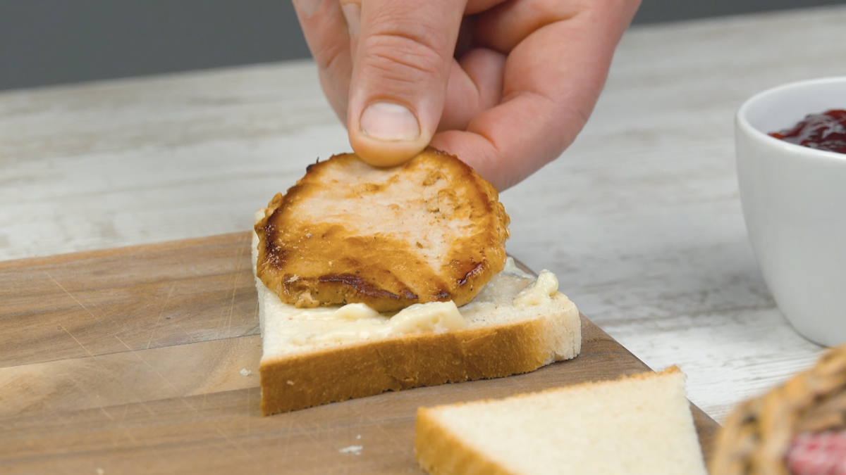 Eine Schweinerückenscheibe wird auf den Gorgonzola auf der Toasthälfte gelegt