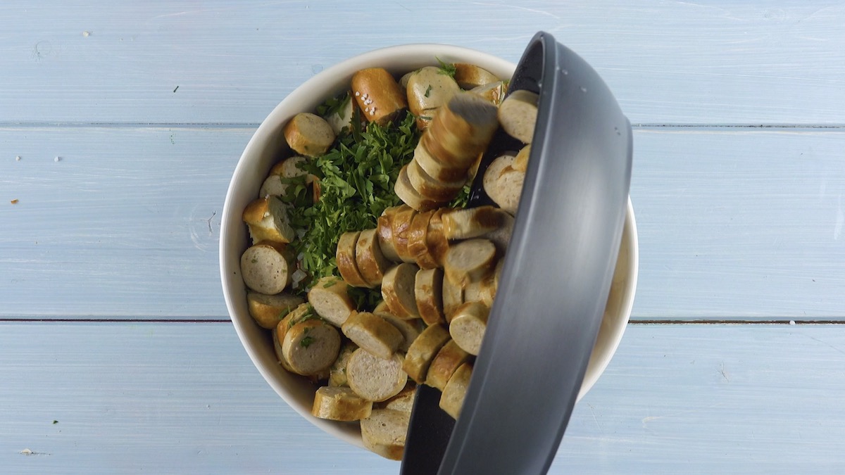 Klein geschnittene und angebratene Bratwürste werden zu Brezelstücken hinzugegeben