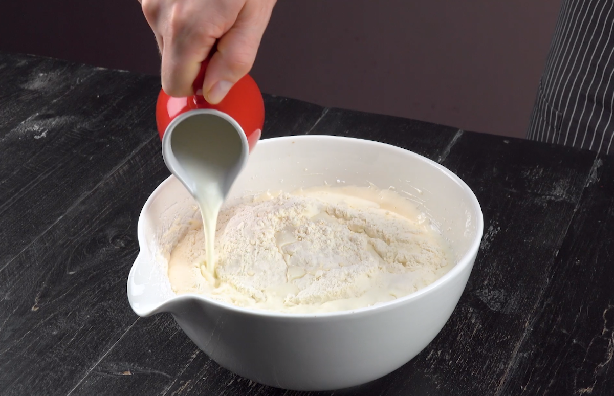 Milch wird zu den anderen Zutaten in Schüssel gegeben