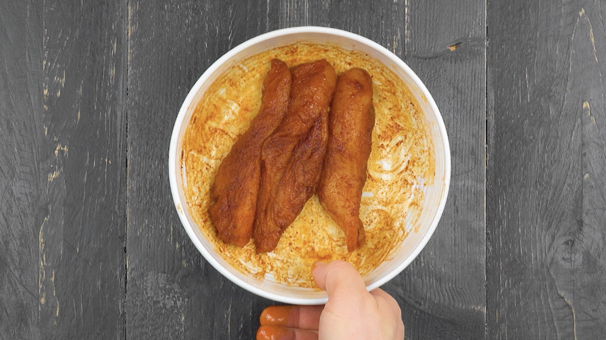 Hähnchenbrust wird in Schüssel mariniert