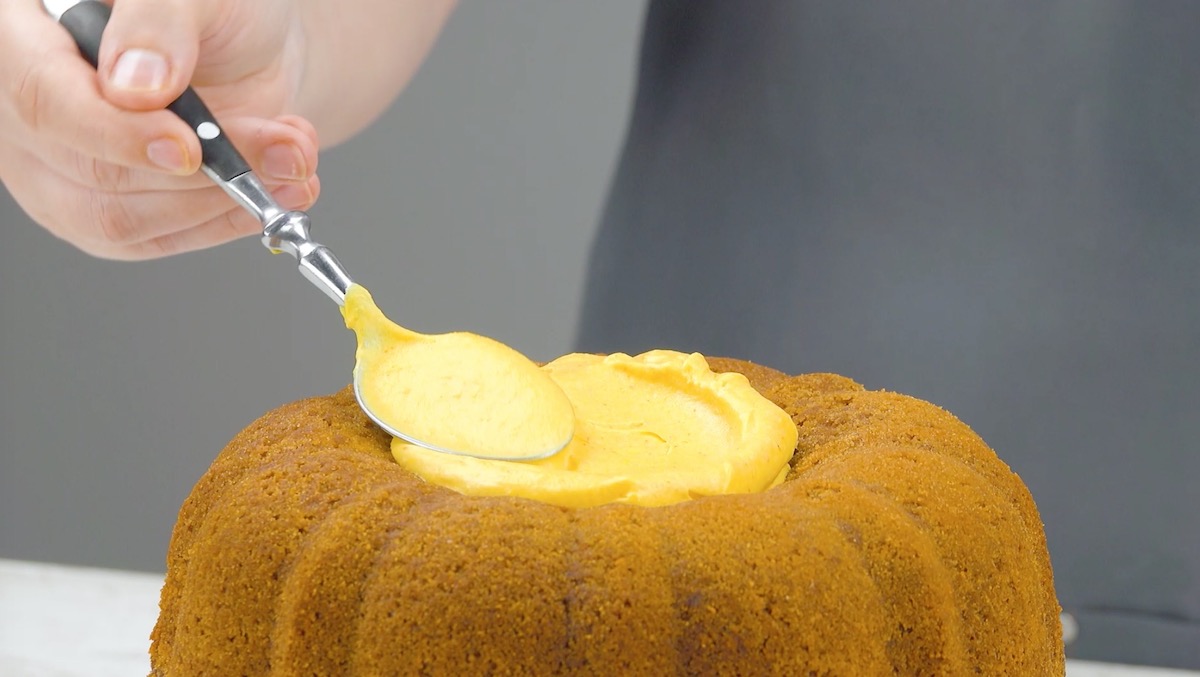 Weitere Frischkäsecreme wird auf einem Kuchenboden verstrichen