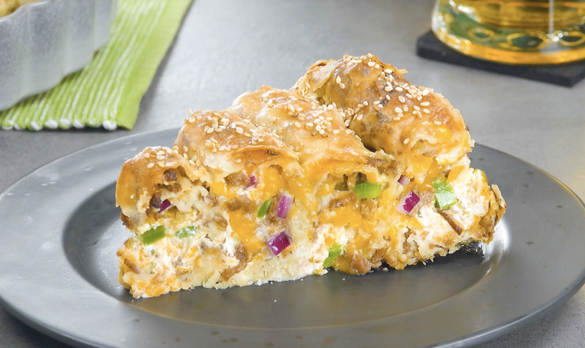 Ein Stück Cheeseburger-Kuchen mit Frischkäsefüllung auf Teller