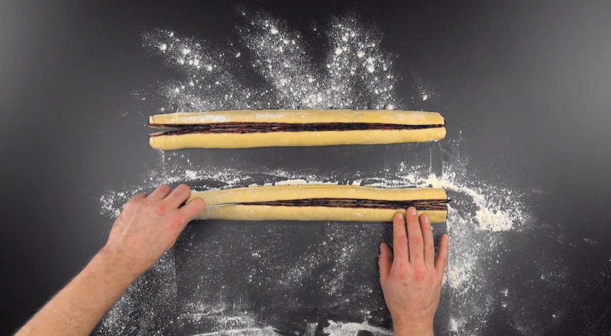 Hefeteig mit Heidelbeer-Masse wird zu 2 Rollen aufgerollt und der Länge nach aufgeschnitten