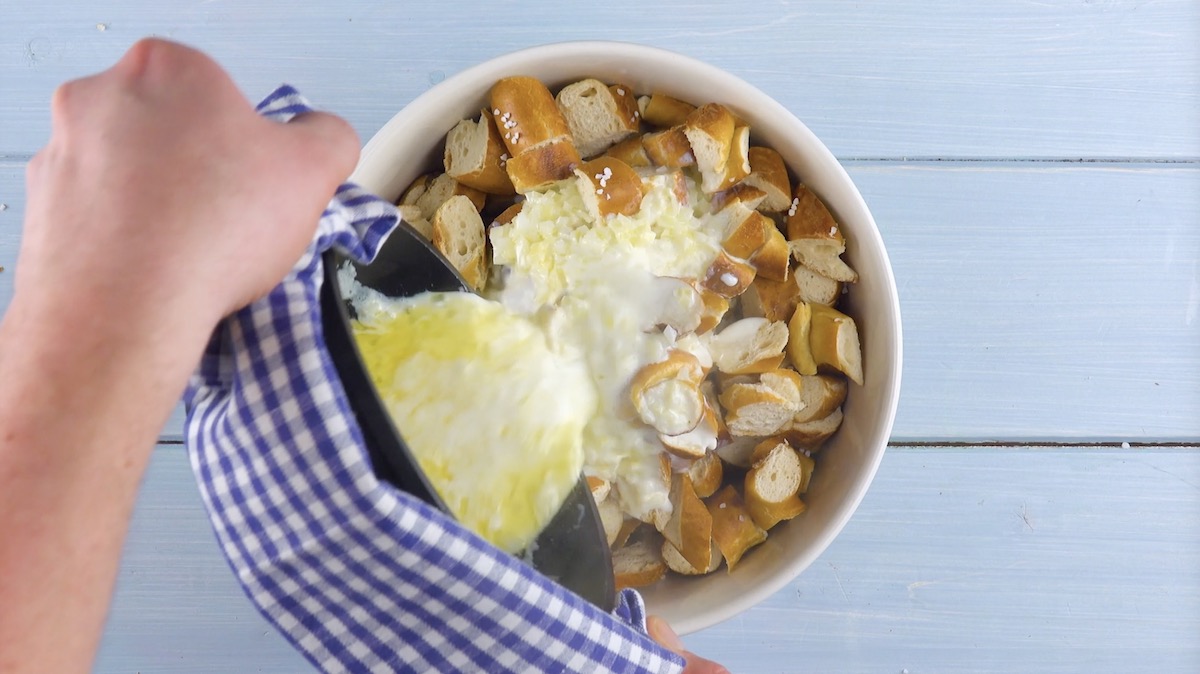 Heiße, flüssige Butter und Milch werden in Schüssel mit Brezeln gegossen