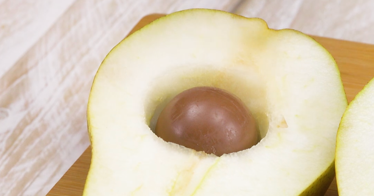 Halbierte Birne wird ausgehöhlt und mit Praline gefüllt