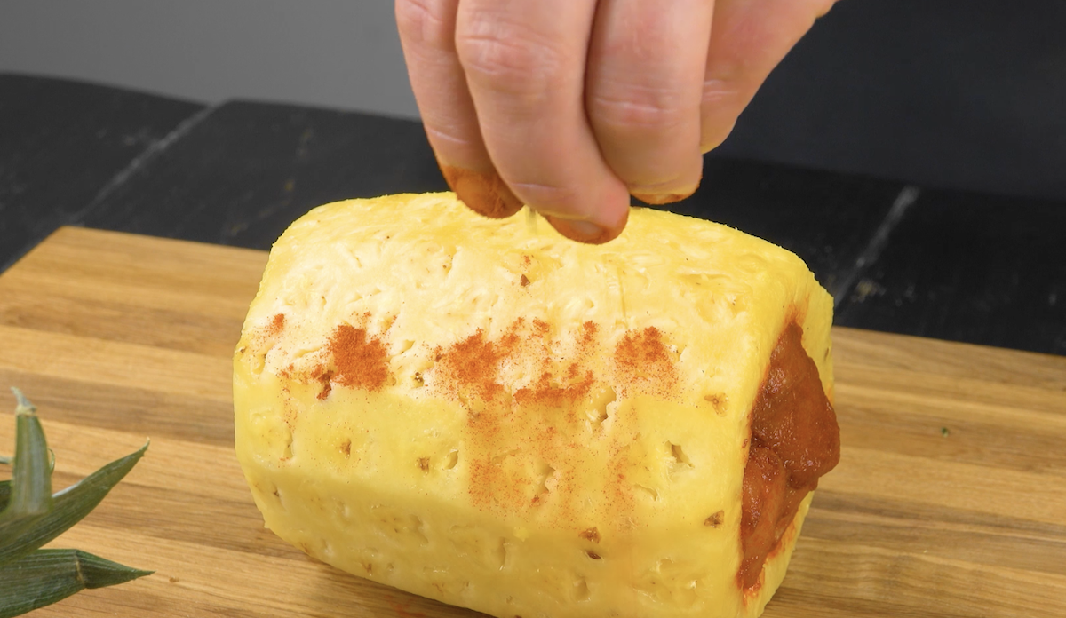 Mit Hähnchenbrust gefüllte Ananas wird mit Paprika- und Cayennepulver gewürzt