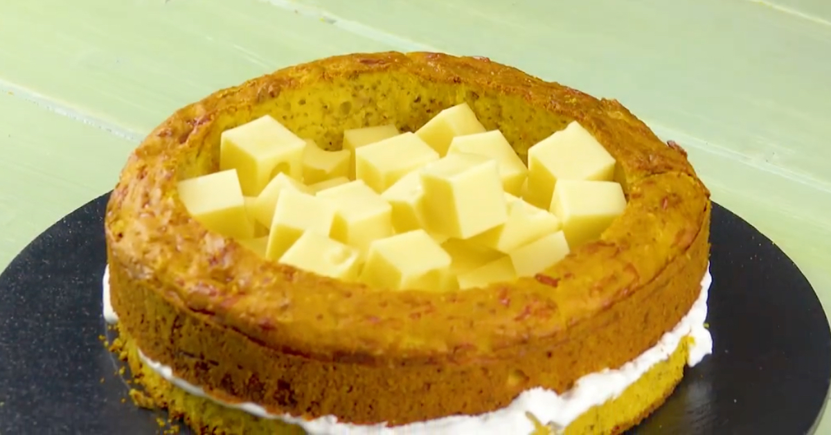 Käsewürfel werden auf einen Kuchen gelegt