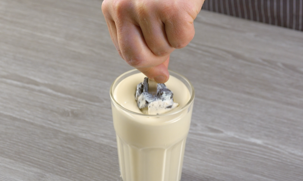 Oreo-Eis wird in weiße, flüssige Kuvertüre getaucht