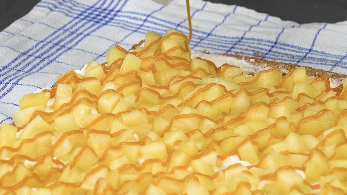 Karamellsoße wird auf Apfelstücken verteilt