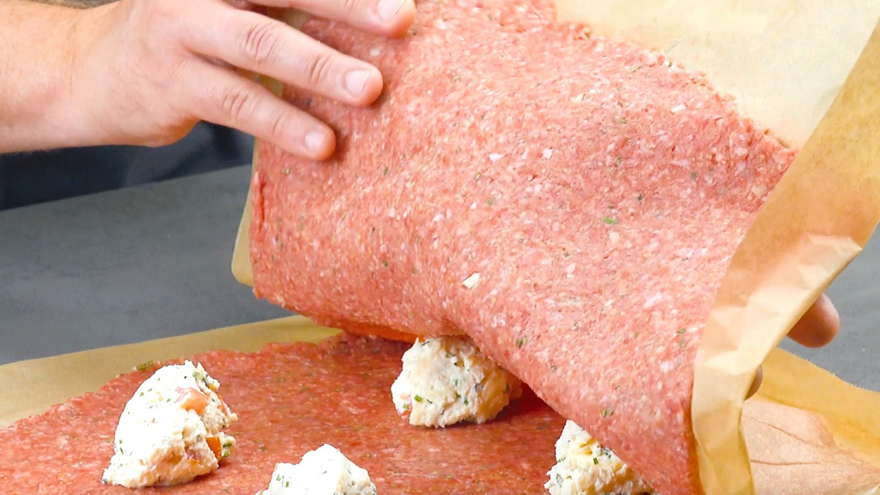 Zweite Hackfleischschicht wird auf Käsefüllungen auf Hackfleischschicht gelegt