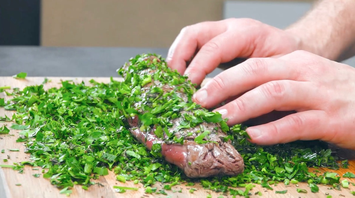 Scharf angebratenes Rinderfilet wird in kleingehackten Kräutern gerollt