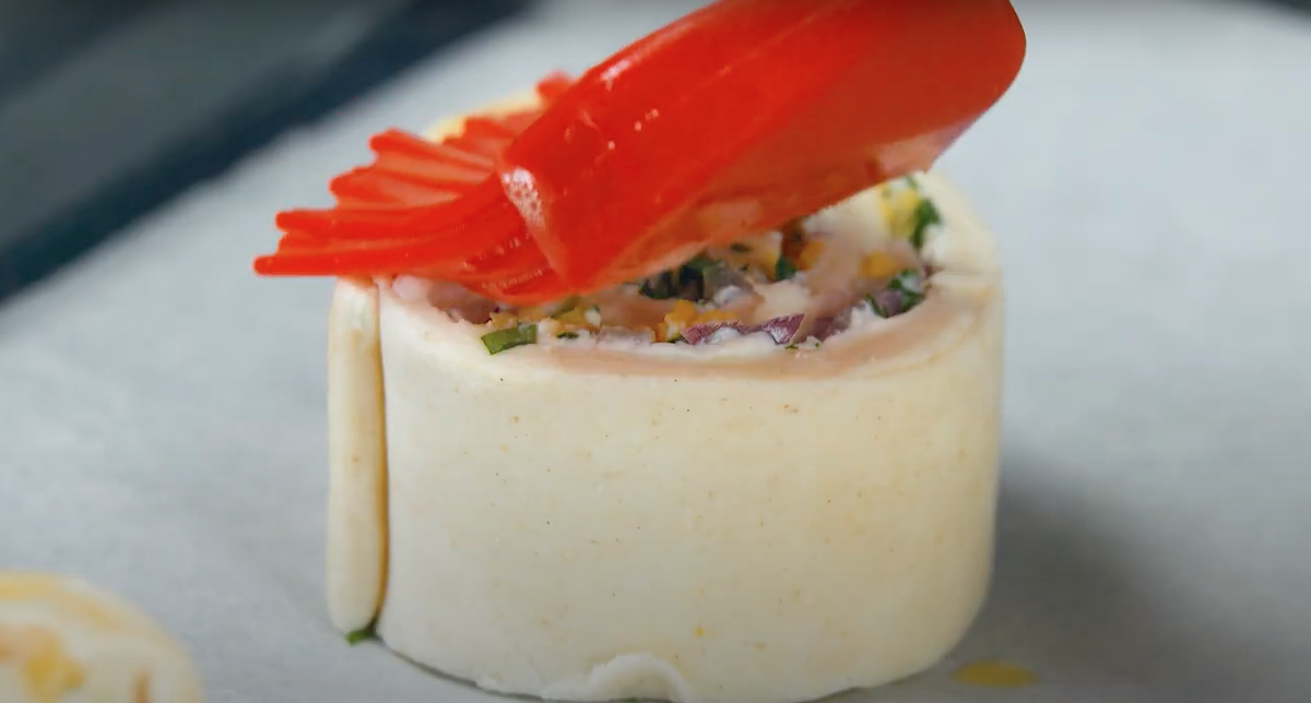 Käse-Bacon-Wirbel wird mit verquirltem Ei bestrichen