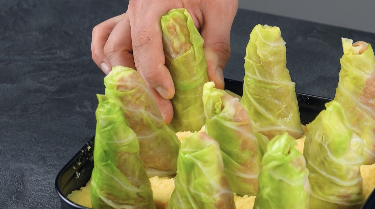 Mit Hackfleisch gefüllte Kohl-Kegel werden hochkant in eine Kuchenform gestellt