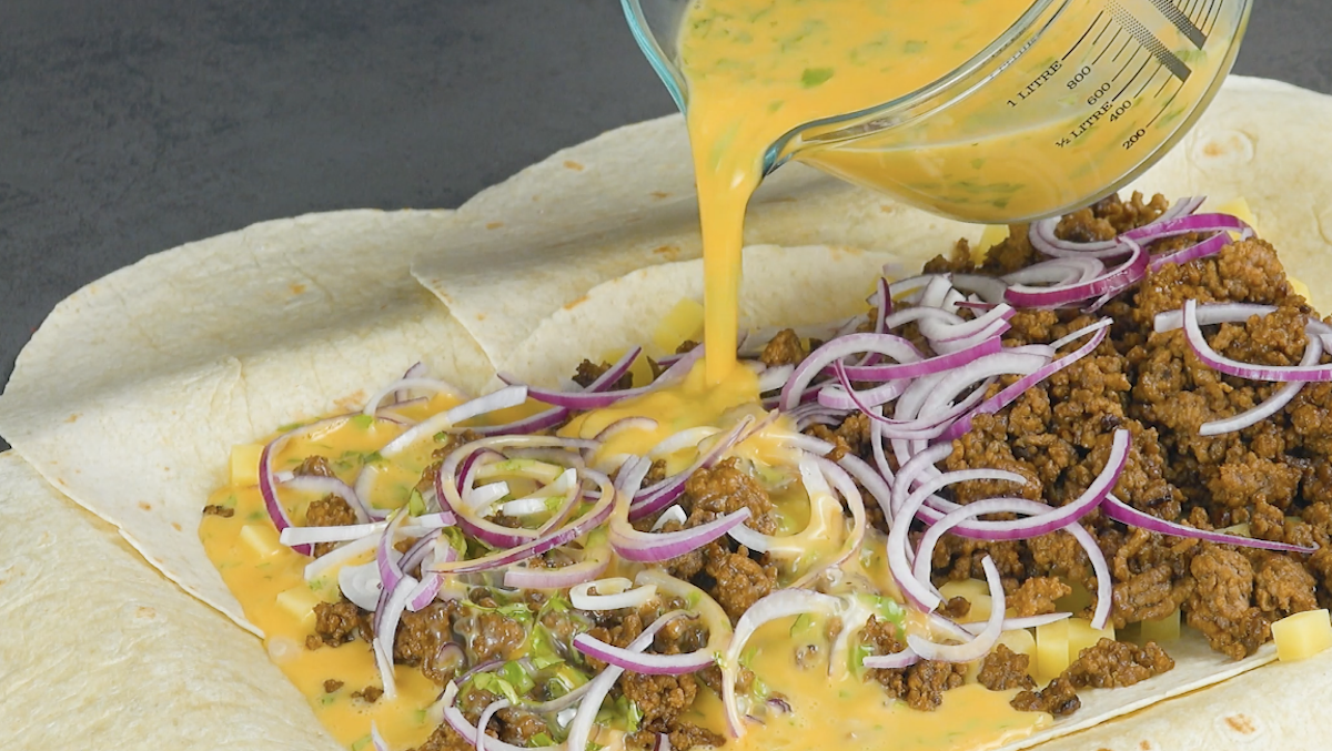 Die Eier-Miclh-Mischung wird über der Füllung der tortillas verteilt