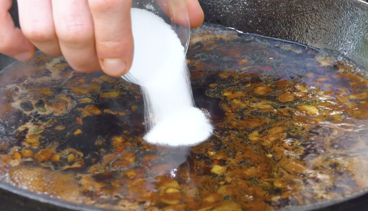 Salz wird in Pfanne mit Soße gegeben