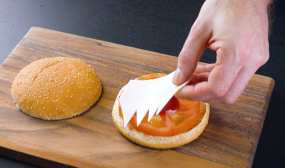 Käse in Zahnoptik wird auf Burger gelegt