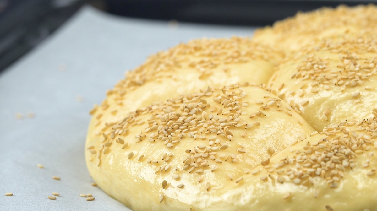 Sesamkörner werden auf Teig gestreut