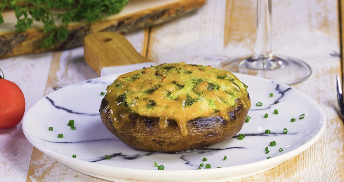 Ein gefüllter Riesen-Champignon mit Spinat und Käse auf Teller