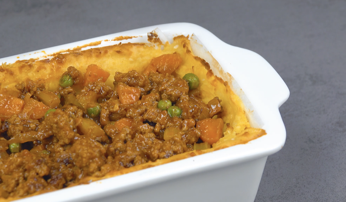 Hackfleisch wird in vorgebackenes Kartoffelpüree in Auflaufform gefüllt