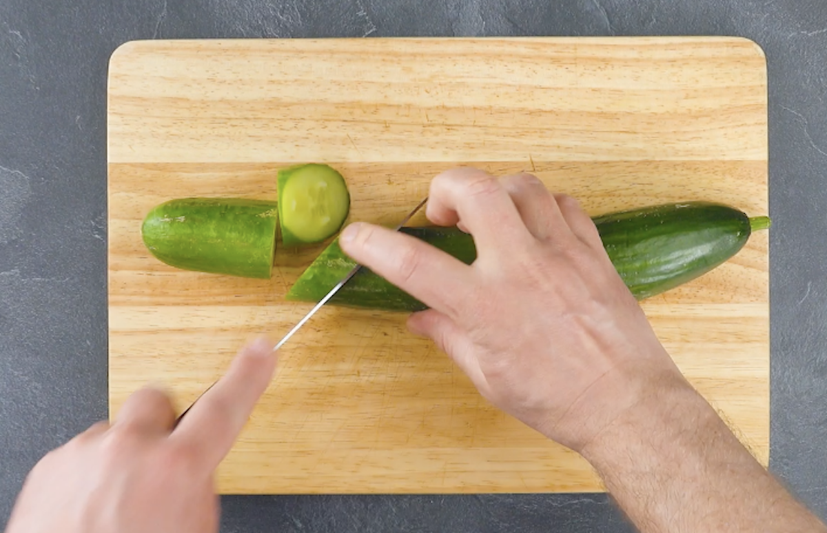 Endstück und eine schräg geschnittene Scheibe werden von Gurke abgeschnitten