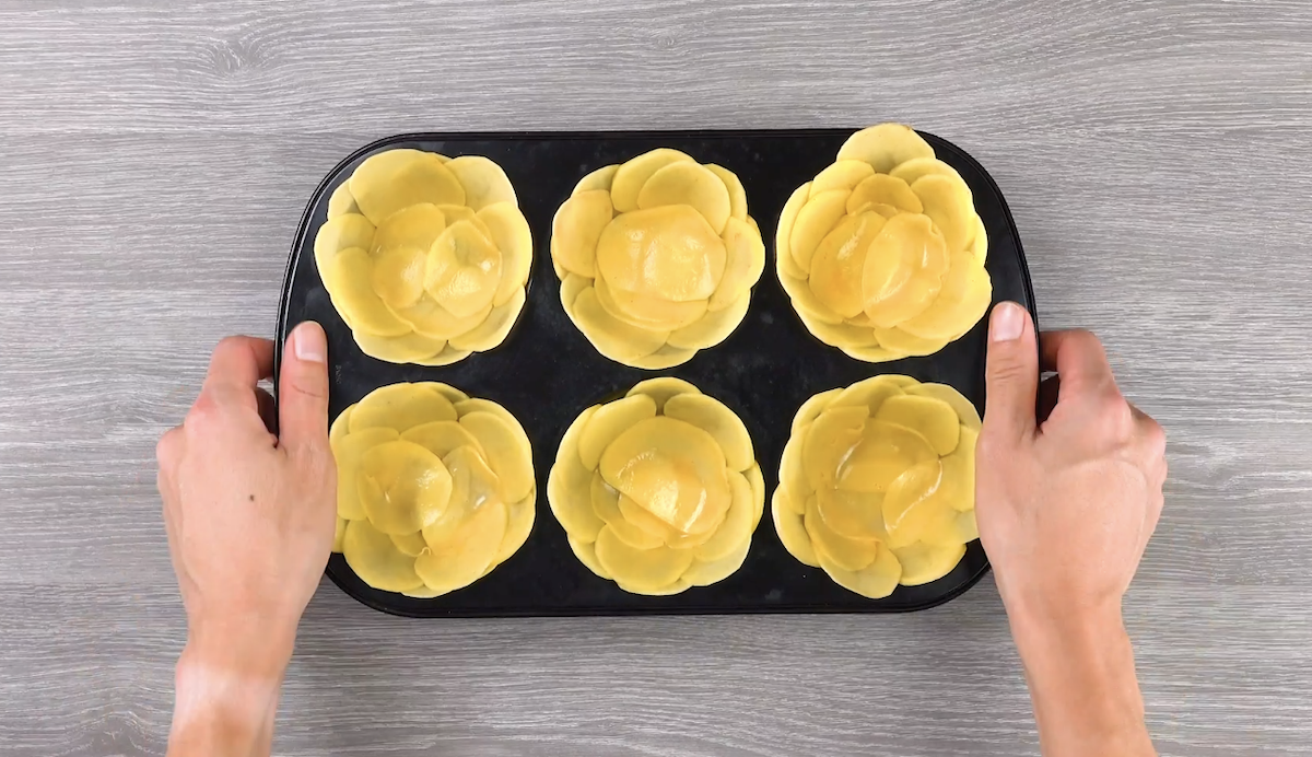 Die Mulden einer Muffinform wurden mit dünnen Kartoffelscheiben ausgelegt