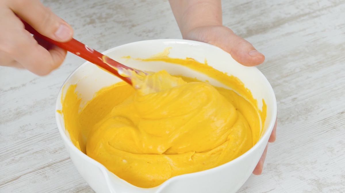 Eine Frischkäsecreme mit püriertem Hokkaido-Kürbis wird in einer Schüssel zubereitet