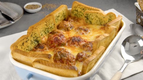 Köstlicher Hackbällchen-Auflauf mit Kräuterbutter-Toast-Zaun in der Auflaufform.