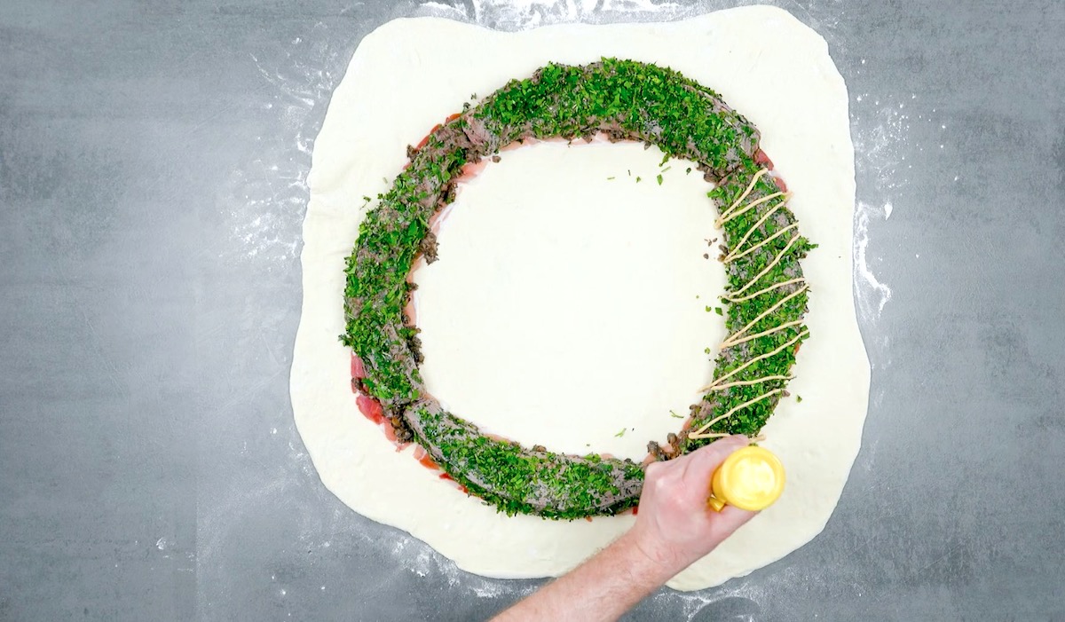 Pilze und Rinderfilet werden auf Schinken gelegt und mit Senf gewürzt