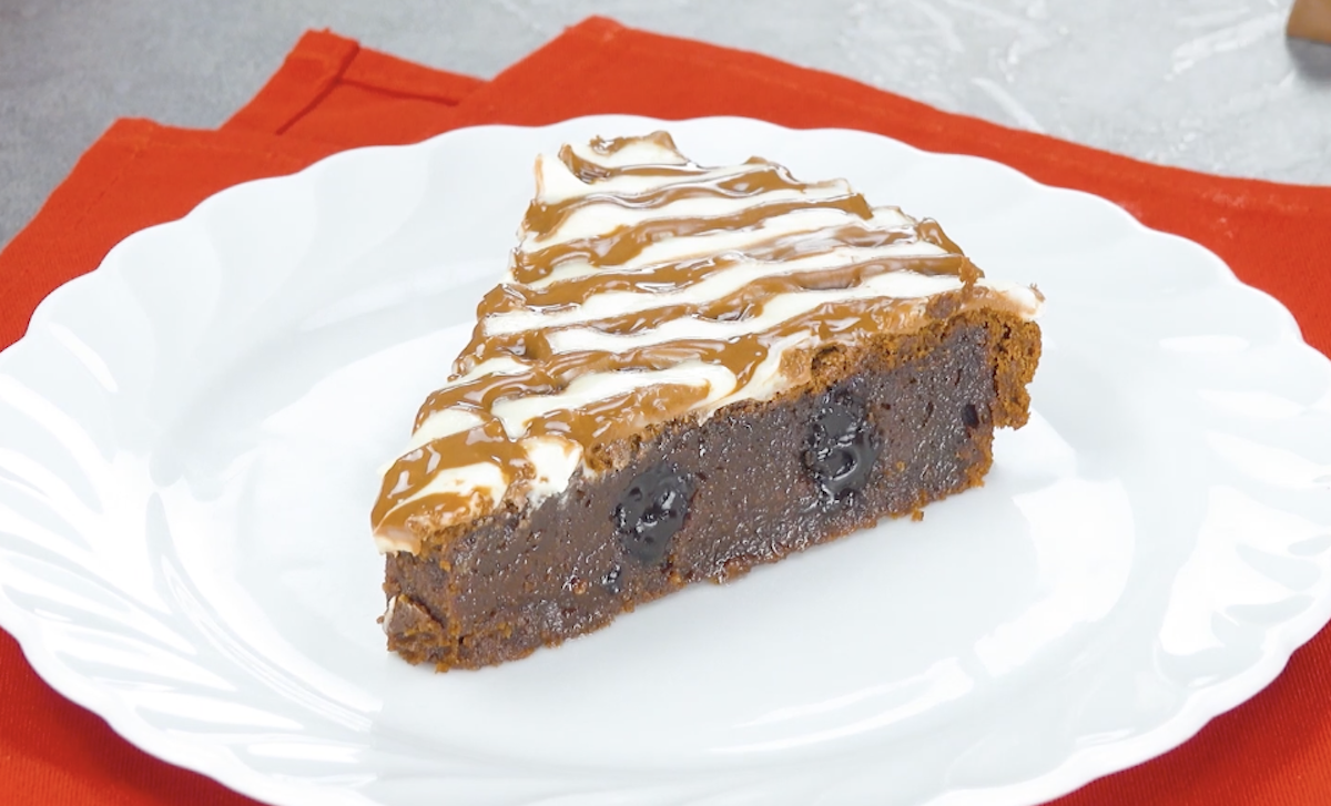 Ein Stück saftiger Schokoladenkuchen mit kinder Schokolade auf einem Teller.