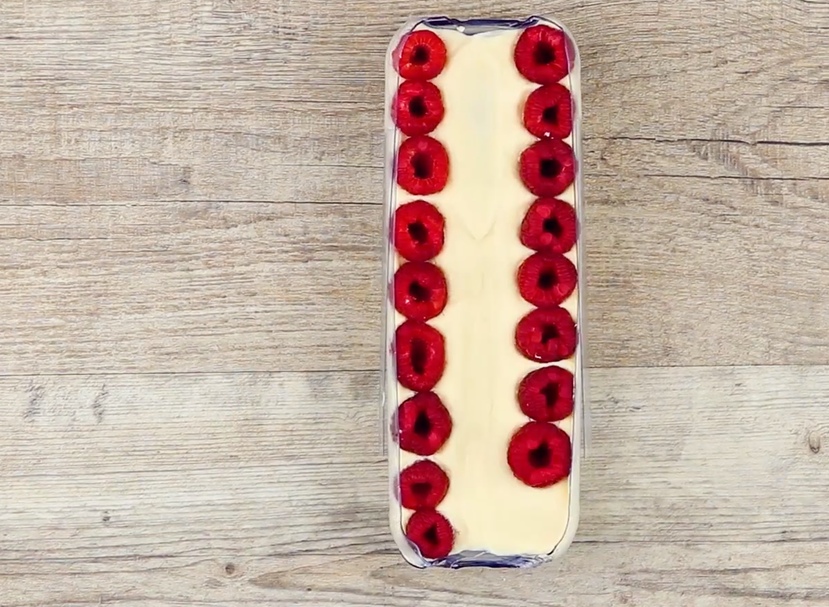 Mascarponecreme im Himbeer-Tiramisu wird am Rand mit Himbeeren belegt