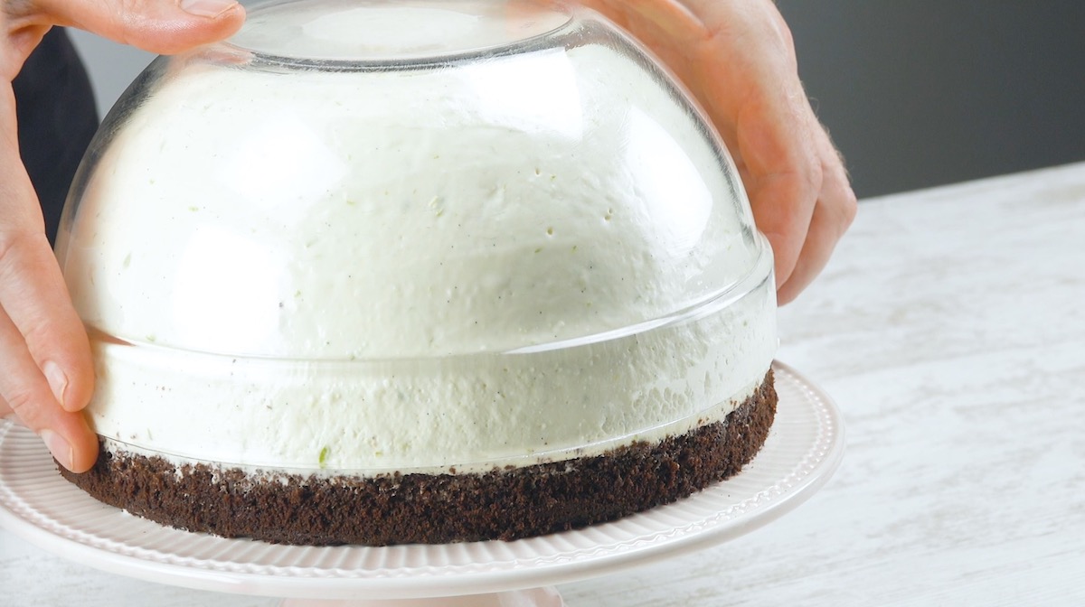 Frischkäsecreme in einer Schüssel wird über die Melone mit Erdbeeren gestülpt