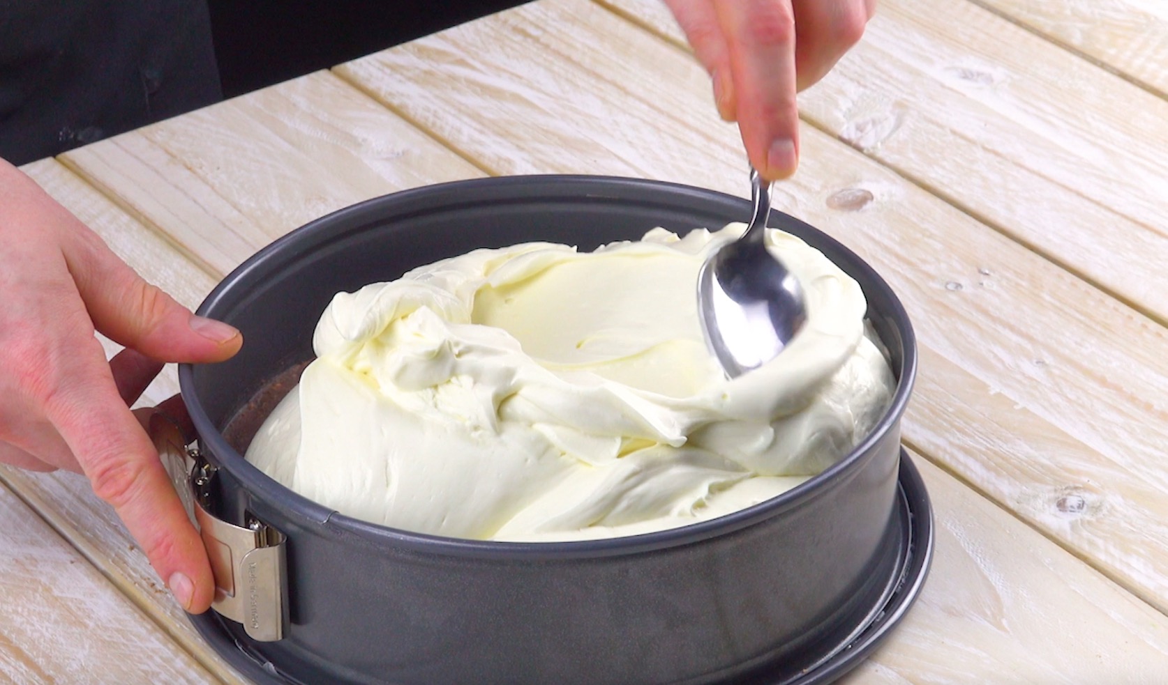 Frischkäsecreme wird auf Boden in Kuchenform verteilt