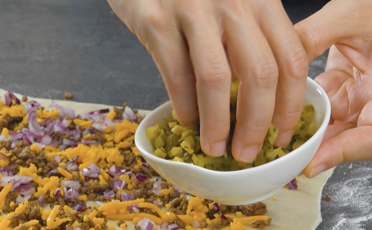Teig wird mit klein gehackten Gewürzgurken bestreut