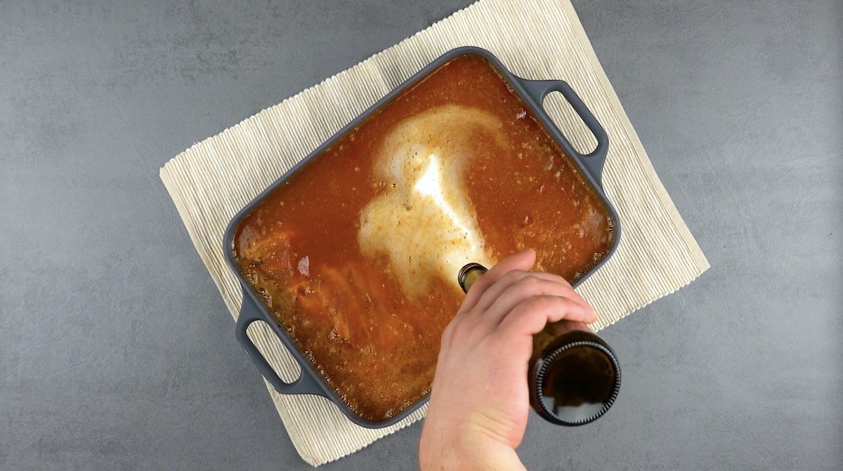 Bier wird über Rippchen in Barbecuesoße gegossen