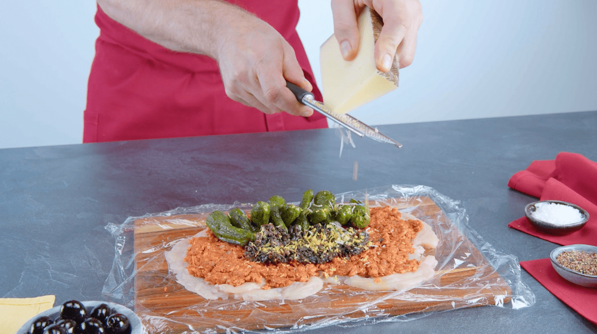 Manchego wird auf Pimientos und Chorizobrät gerieben