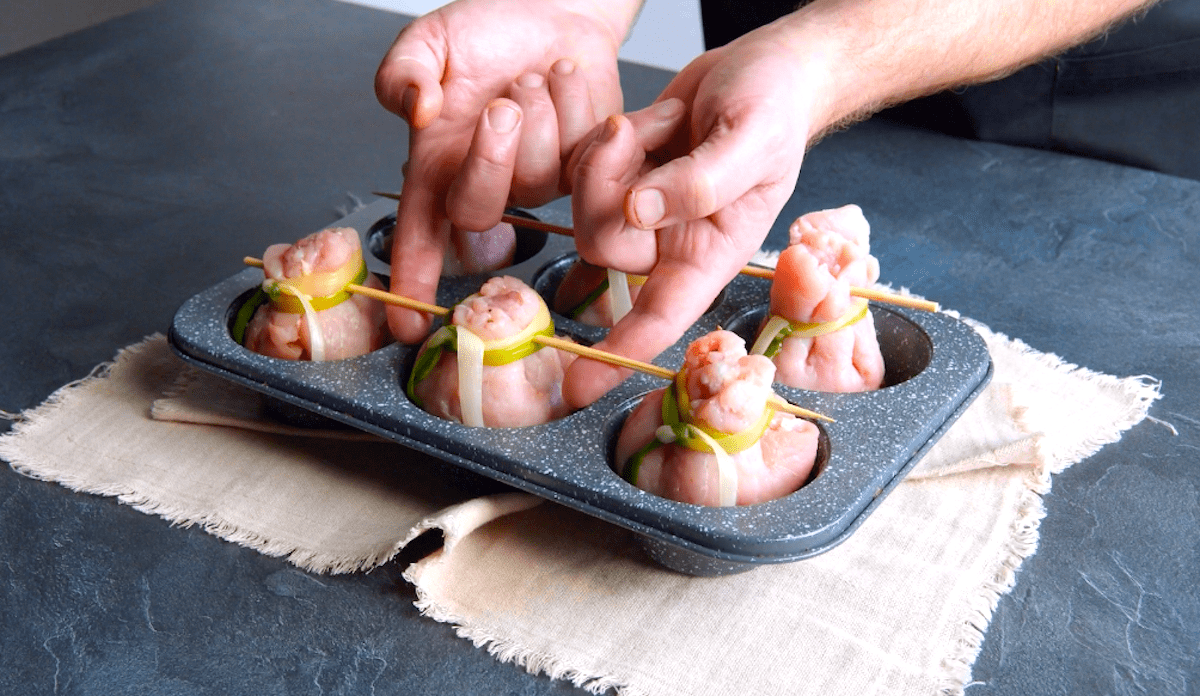 Gefüllte Schweinefleisch-Säckchen werden in die Mulden einer Muffinform gelegt.