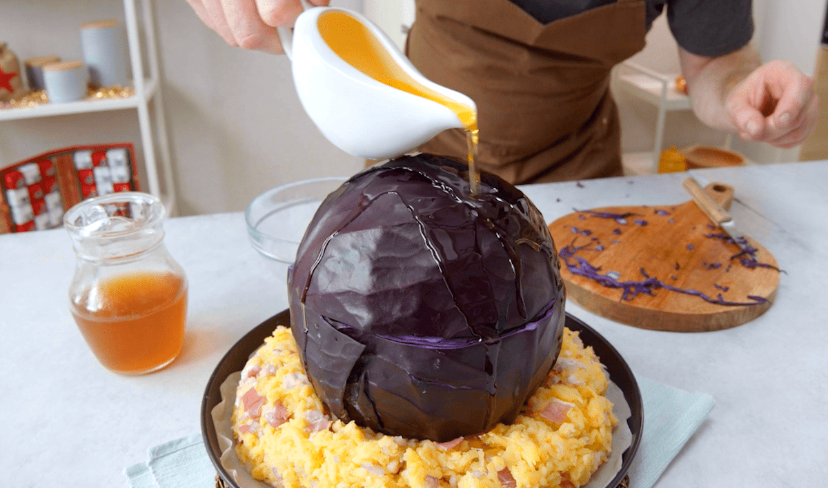 Ein mit Gulasch gefüllter Rotkohl wird mit flüssiger Butter übergossen