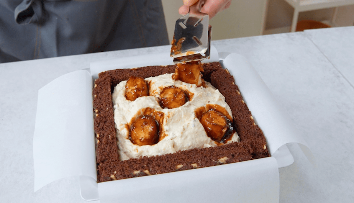 Karamellisierte Bananen werden in Bananencreme in eine Kuchenform gedrückt