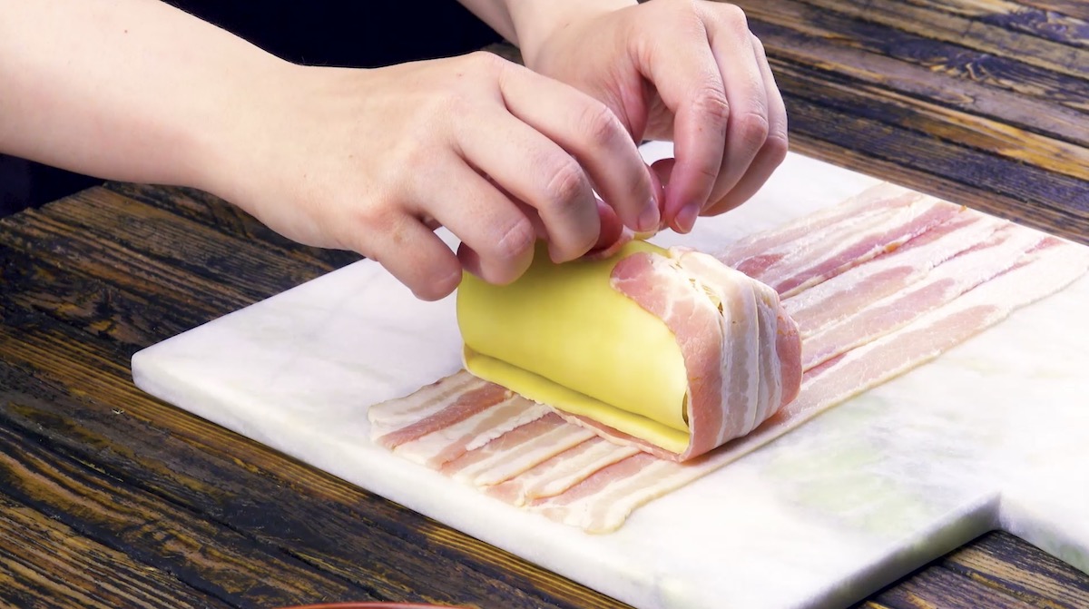 Die Baconscheiben werden über Mais mit Käse gelegt