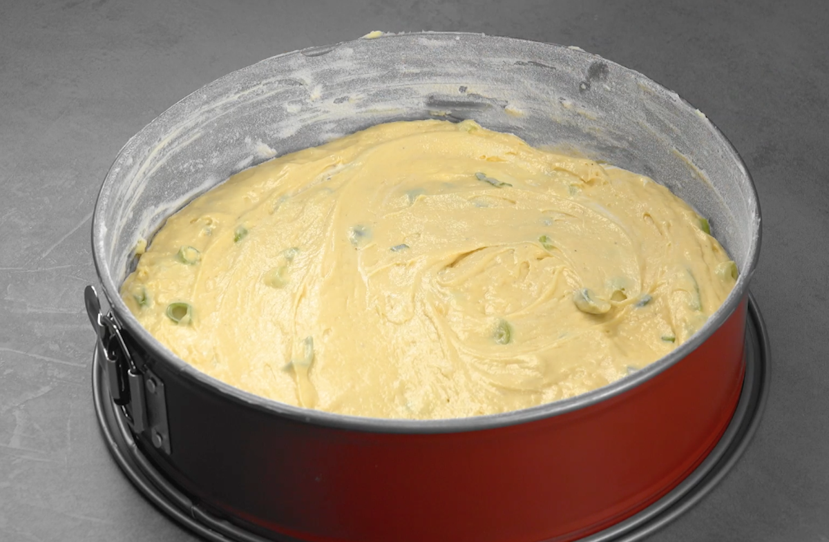 Teig für Zwiebelkuchen wird in bemehlte Springform gefüllt