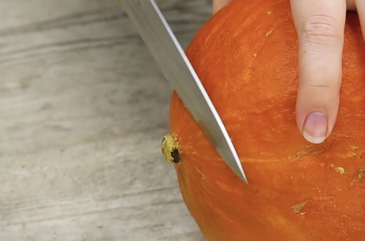 Strunk des Hokkaidokürbisses wird abgeschnitten