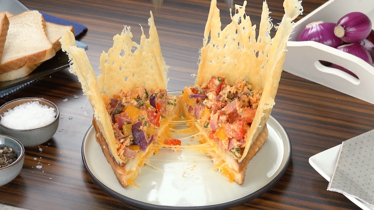 In der Mitte durchgeschnittenes Toastbrot mit Käsekrone und Rührei