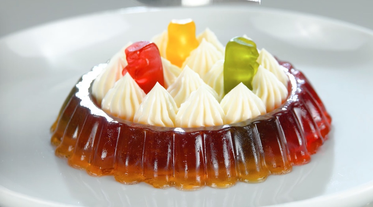 Gummibärchen-Törtchen mit Sahne und drei Gummibärchen in grün, gelb und rot